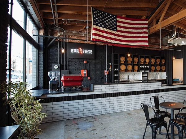 Modern cafe interior with American flag and brick wall.