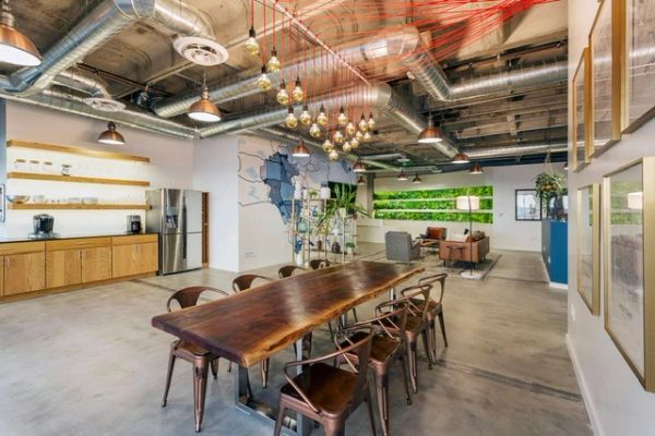 Modern conference room with industrial design and wooden table.