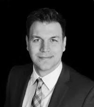 Black and white portrait of a man in a suit and tie.