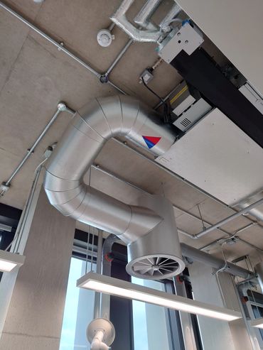 Ceiling HVAC ductwork and fan in an office.
