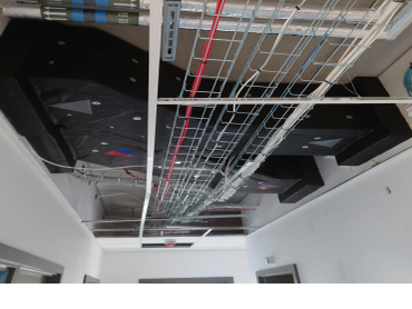 Ceiling with exposed wiring and ventilation ducts.