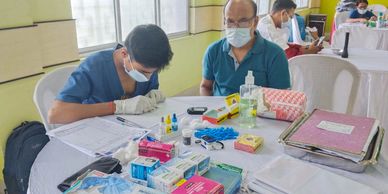 Medical professional conducting tests with patient at a health camp.