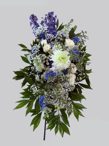 Elegant floral arrangement with white and blue flowers and lush green leaves.