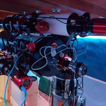 High-tech telescope with multiple attachments in an observatory dome.