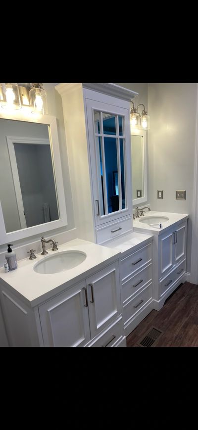 Modern white double vanity with sinks and mirrors in a bathroom.