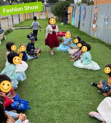 Children dressed up and walking on grass in a playful fashion show.