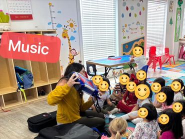 Teacher playing music for children in a colorful classroom.