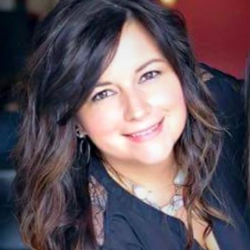 Smiling woman with long wavy hair and a black top.
