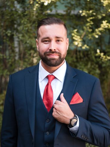 Man in formal suit with red tie and pocket square.