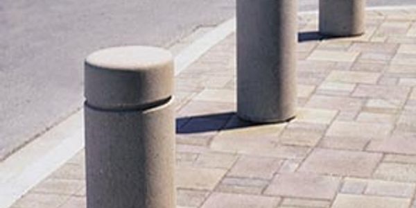 Concrete bollards on a tiled sidewalk.