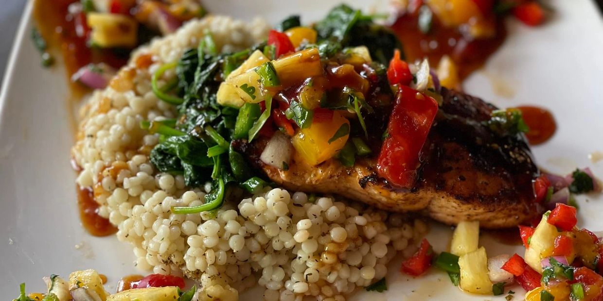 Grilled Salmon served over couscous with spinach and homemade salsa