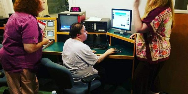 A client working at a community access TV station and learning how to use editing software.