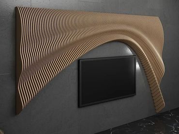 Modern TV wall mount with a wavy wooden panel design in a dark room.