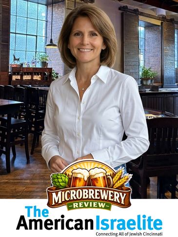 Woman in a white shirt smiling inside a microbrewery.