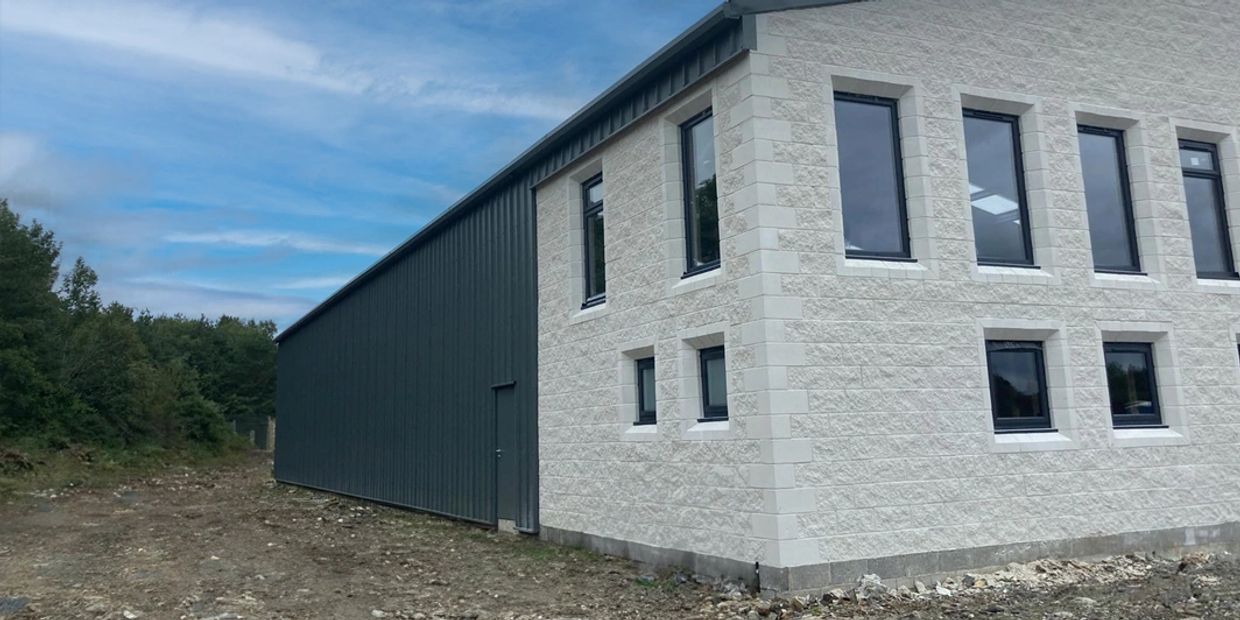 Partially clad warehouse and office building.
