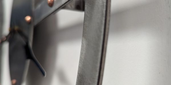 Close-up of a metal sword hanging on a wall.