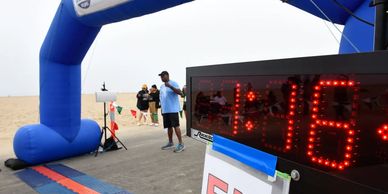 Finish line of a 5K run with a digital timer showing 41:16.
