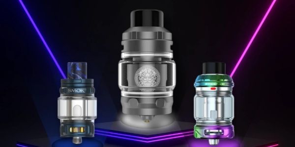Three modern vape tanks on a neon-lit stage.