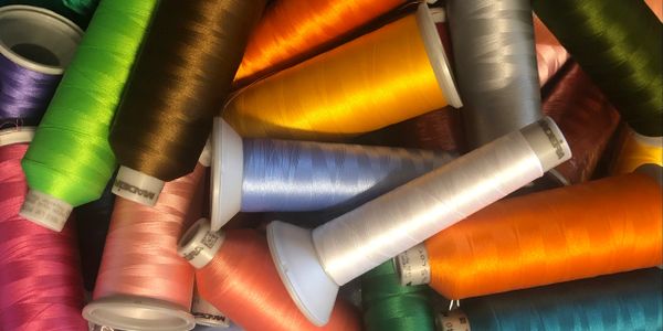 Colorful spools of thread arranged closely together.