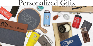 Assorted custom branded merchandise including tumblers, coasters, and leather goods.