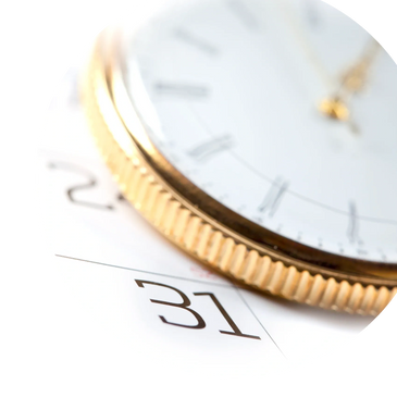 Close-up of a gold-rimmed watch face over a calendar showing the 31st.