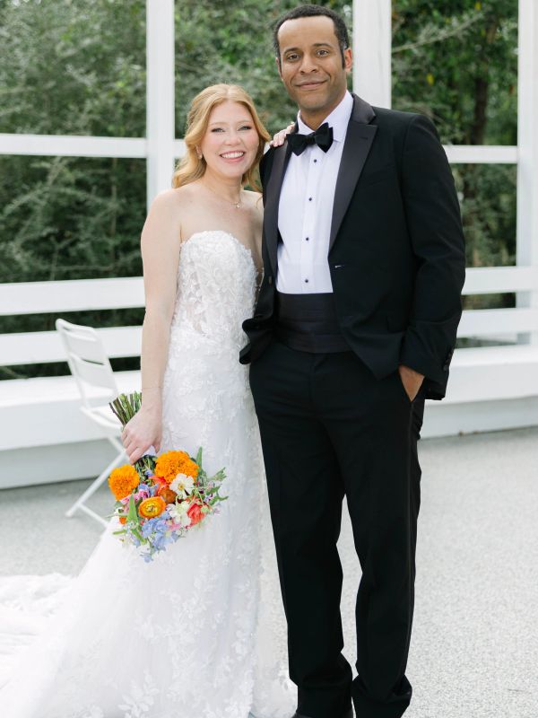 A smiling bride and groom posing together on their wedding day.