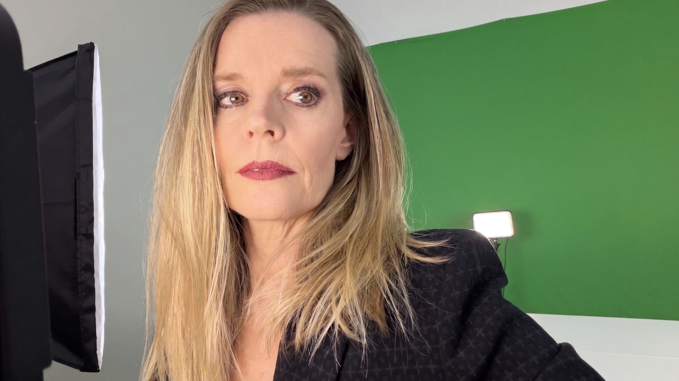 Blond woman in green screen filming studio