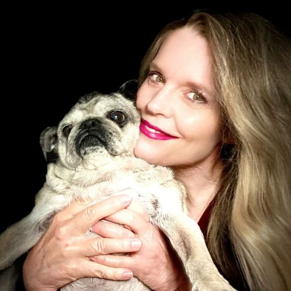 Woman holding her senior fawn pug