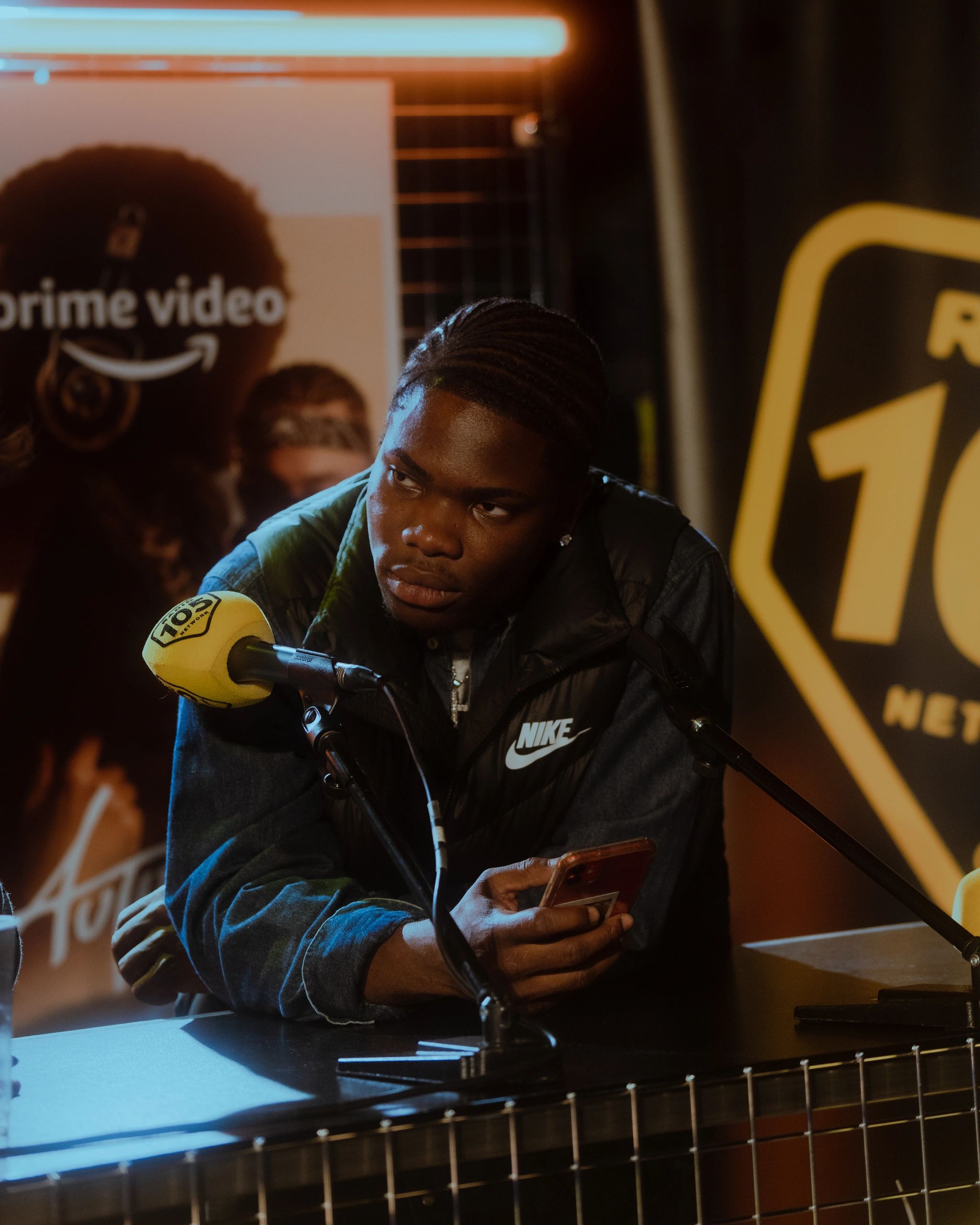 Kevin kalvin seduto difronte al microfono giallo di radio 105 alla prima di Autumn beat, prime video