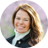 Smiling woman outdoors with windblown hair.