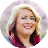 Smiling woman with pink hair highlights.
