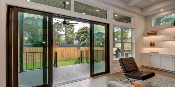 Modern living room with large sliding glass doors opening to a backyard.