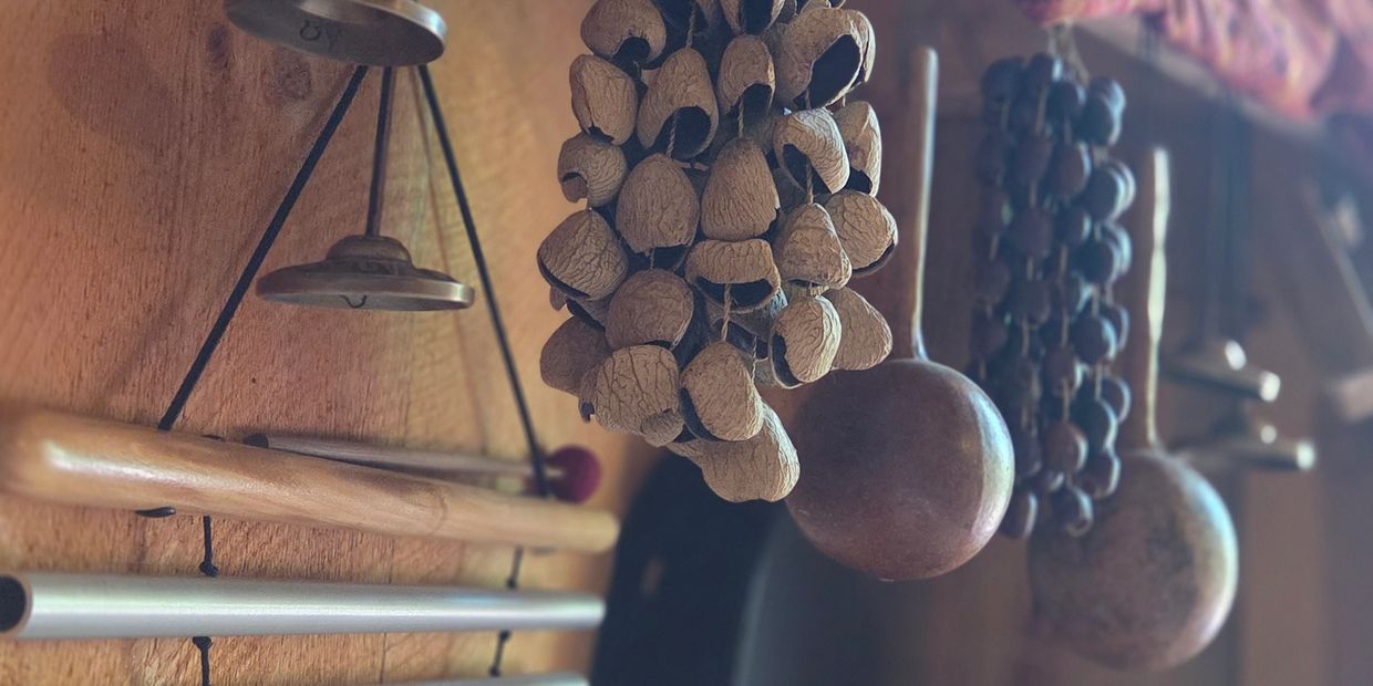 Hanging percussion instruments with a cloth on a wooden wall.