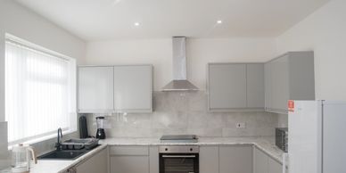 Modern kitchen with gray cabinets and white countertops.