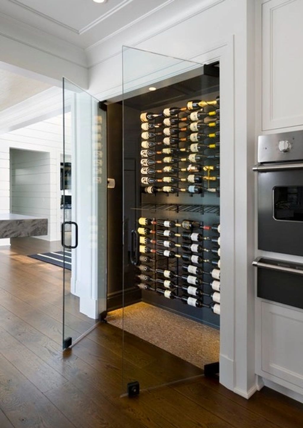 Modern wine storage with glass doors in a sleek kitchen.