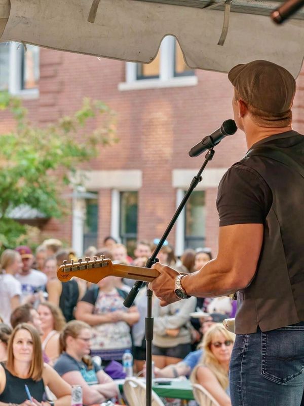 Musician performing outdoors to a crowd.