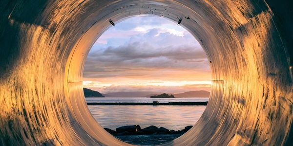 Sunset view through a circular tunnel.