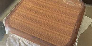 Wooden table top wrapped in plastic.