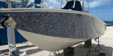 Blue and white boat lifted on stands.