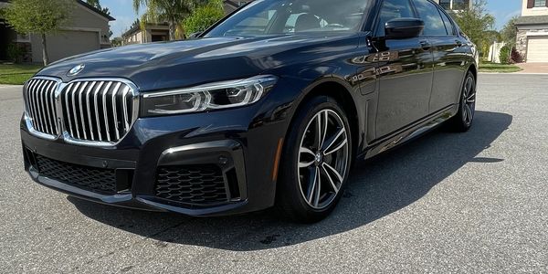 Sleek black BMW sedan parked on a sunny suburban street.