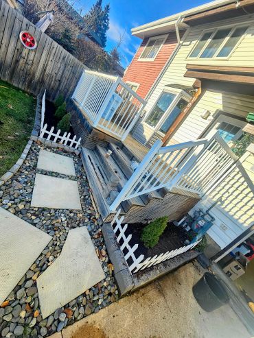 Backyard patio with steps and small garden beds.