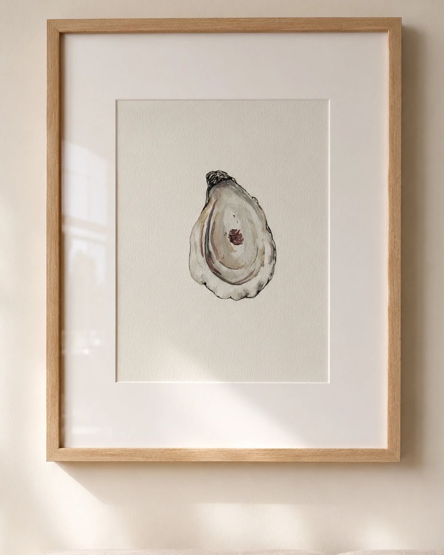 Framed watercolor painting of an oyster on a white wall.