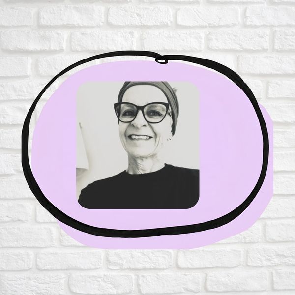 Portrait of lady with headband, short hair and glasses smiling at camera.  