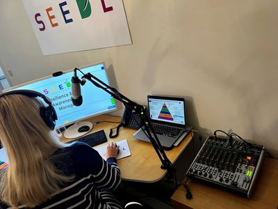 Person recording a podcast or radio show with professional audio equipment.