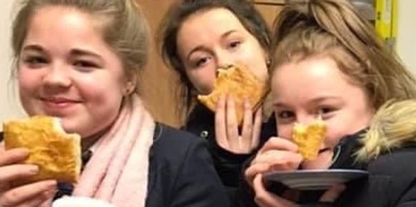 Three young women enjoying pastries together indoors.