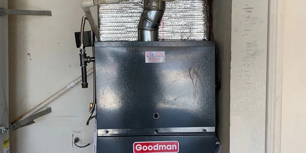 Goodman brand furnace installed in a residential utility room.
