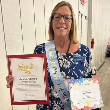 Donna Peterson showing certificates from the San Gabriel Valley District and California Senate honor