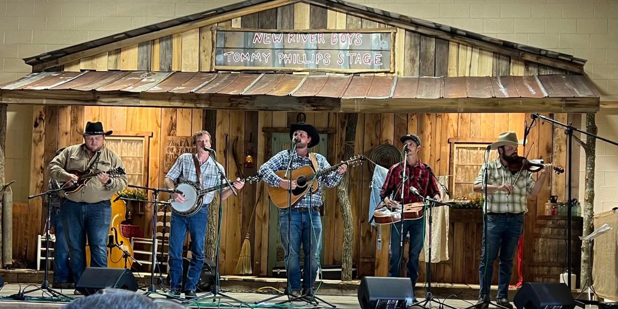 A bluegrass band performs on a rustic wooden stage with vintage decor.