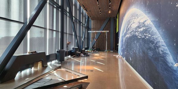 Modern hallway with glass windows and space-themed wall art.