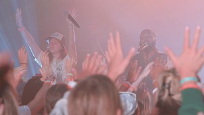 Crowd with raised hands enjoying a live music performance with passionate singers.